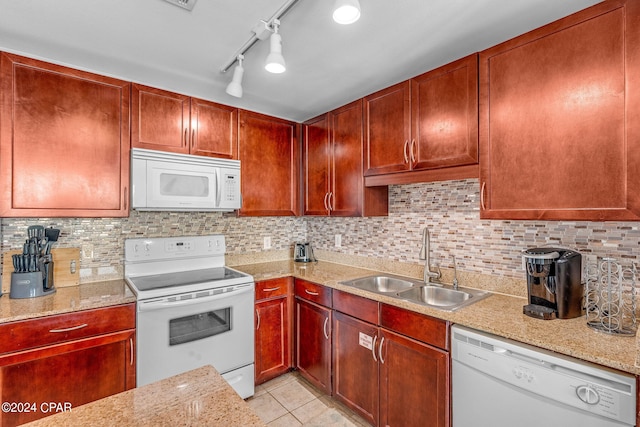 kitchen featuring sink, rail lighting, light tile patterned flooring, light stone countertops, and white appliances