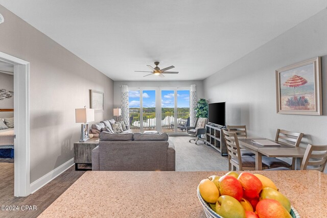 living room featuring dark carpet and ceiling fan