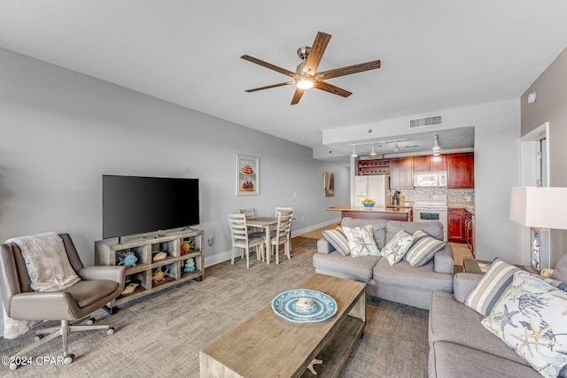 carpeted living room featuring rail lighting and ceiling fan