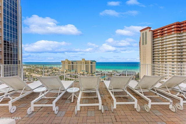 view of patio with a water view and a beach view