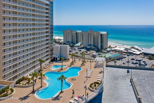 view of pool featuring a water view and a patio area