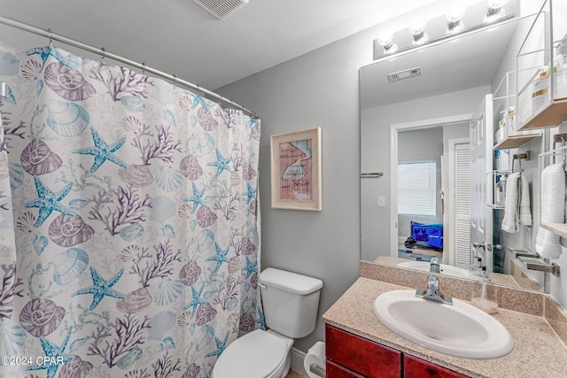 bathroom with a shower with curtain, vanity, and toilet