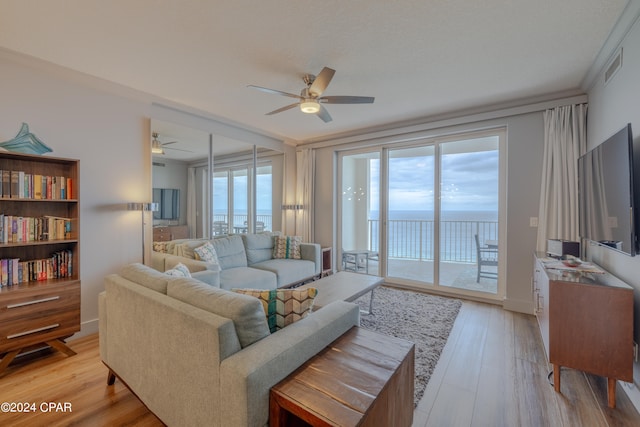 living room with crown molding, ceiling fan, and light hardwood / wood-style flooring