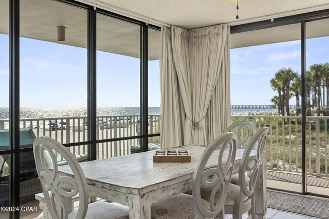 sunroom with a water view and a beach view