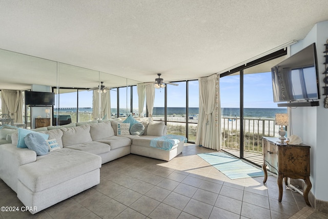 living room with floor to ceiling windows, a wealth of natural light, tile patterned flooring, and a textured ceiling