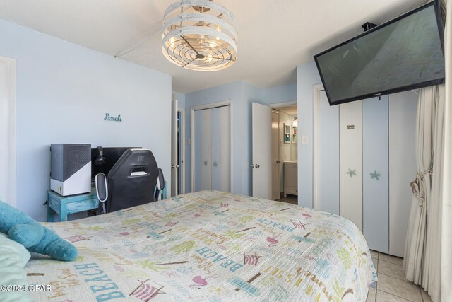 bedroom featuring light tile patterned floors and a notable chandelier