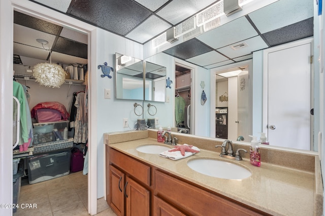 bathroom with tile patterned floors, a drop ceiling, and vanity