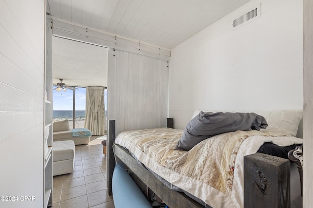 bedroom with tile patterned floors and a water view