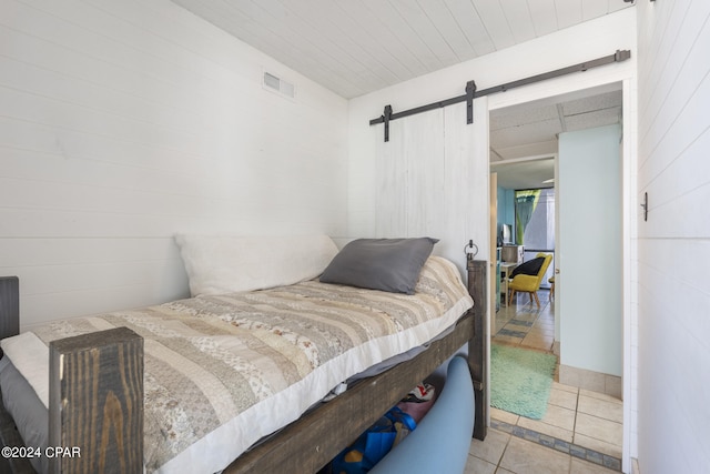 tiled bedroom featuring a barn door