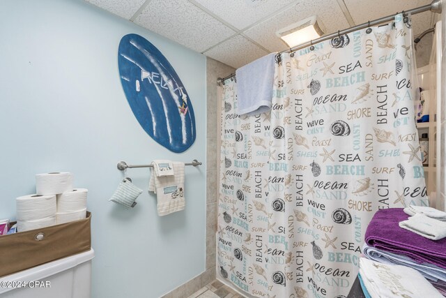 bathroom featuring tile patterned flooring, a shower with curtain, and a paneled ceiling