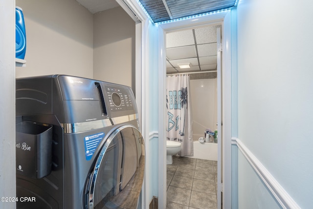 clothes washing area with tile patterned floors and washer / clothes dryer