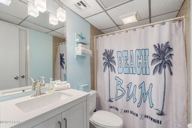 bathroom with a paneled ceiling, vanity, toilet, and a shower with shower curtain