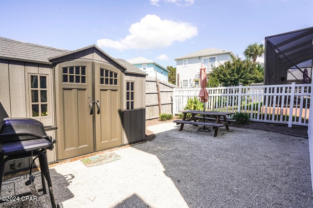 view of patio with area for grilling and a storage unit