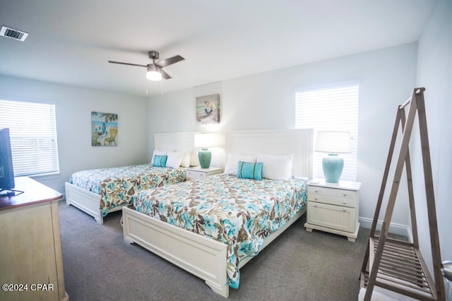 carpeted bedroom featuring multiple windows and ceiling fan