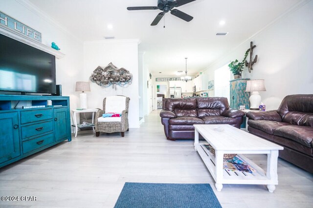 living room featuring ornamental molding, light wood-type flooring, and ceiling fan