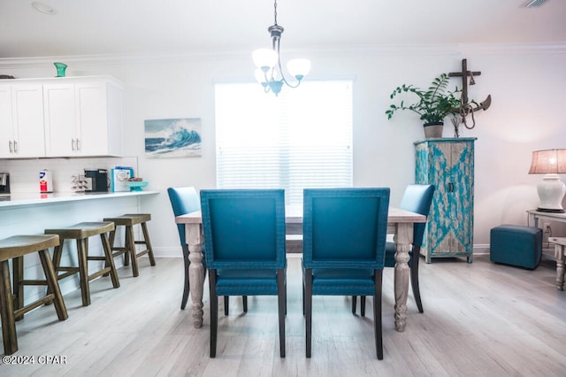 dining room with ornamental molding, a chandelier, and light hardwood / wood-style floors