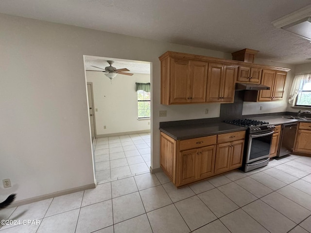 kitchen with appliances with stainless steel finishes, light tile patterned floors, a textured ceiling, ceiling fan, and sink