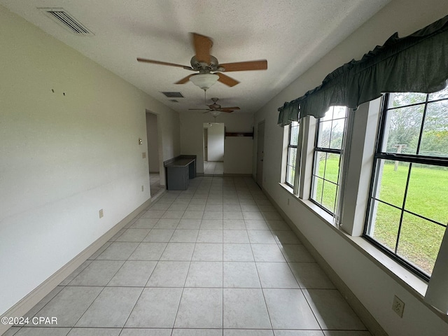 tiled spare room featuring ceiling fan and a textured ceiling