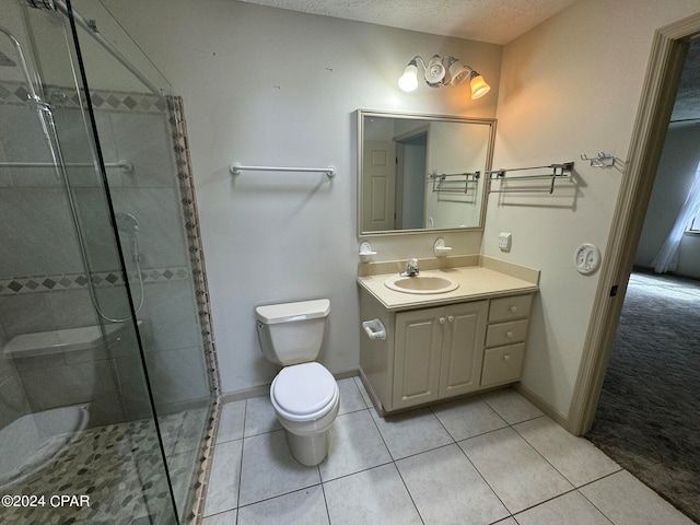 bathroom with a shower with shower door, vanity, a textured ceiling, tile patterned flooring, and toilet