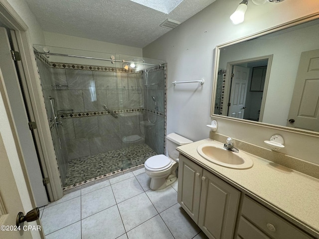 bathroom featuring a textured ceiling, an enclosed shower, a skylight, vanity, and toilet