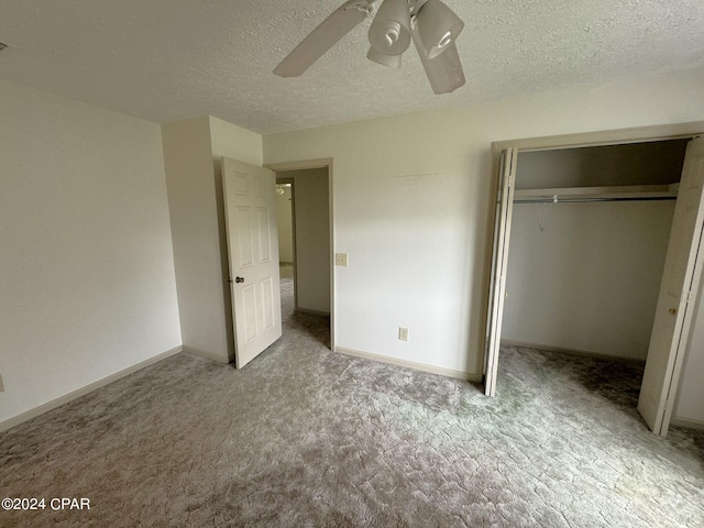 unfurnished bedroom with a closet, ceiling fan, carpet flooring, and a textured ceiling