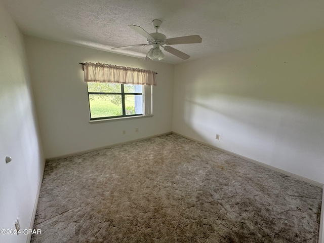 carpeted empty room with a textured ceiling and ceiling fan