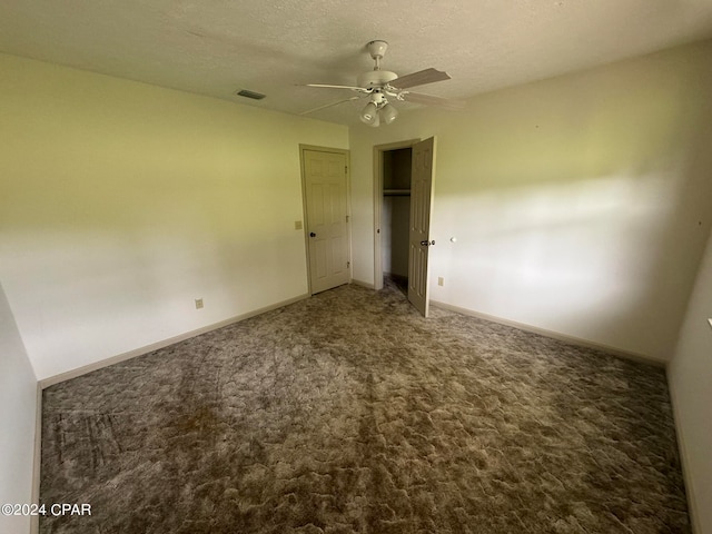 carpeted spare room featuring a textured ceiling and ceiling fan