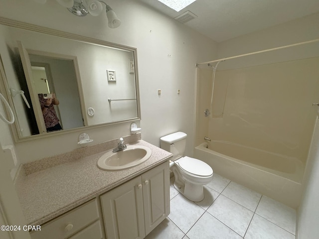 full bathroom with tub / shower combination, vanity, tile patterned flooring, a skylight, and toilet