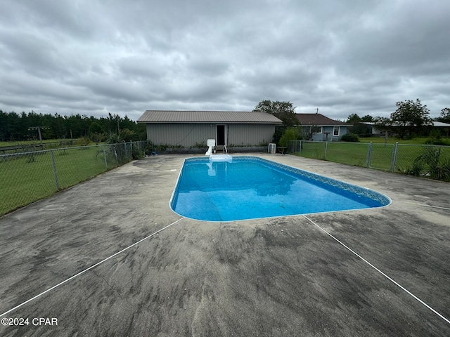 view of pool featuring a patio and a yard