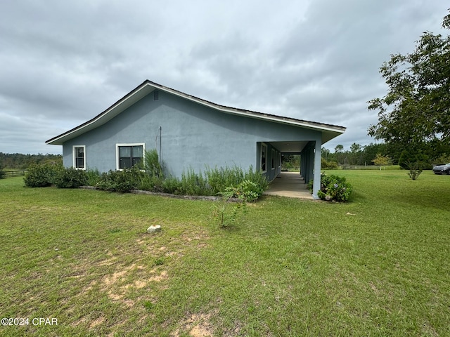 view of side of property with a lawn and a carport