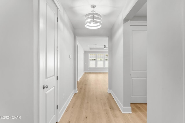 hall with a chandelier and light hardwood / wood-style floors