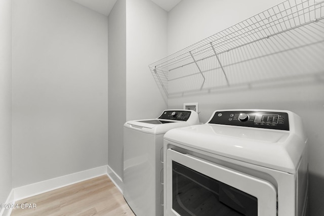 laundry room with light wood-type flooring and independent washer and dryer