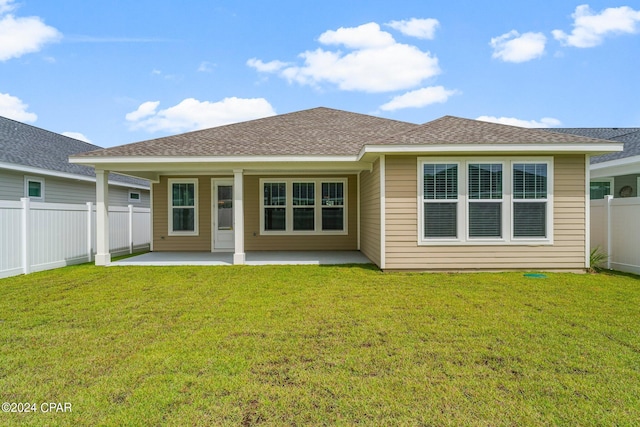 rear view of property featuring a yard and a patio