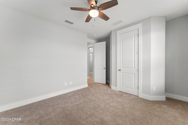 unfurnished bedroom with light colored carpet and ceiling fan