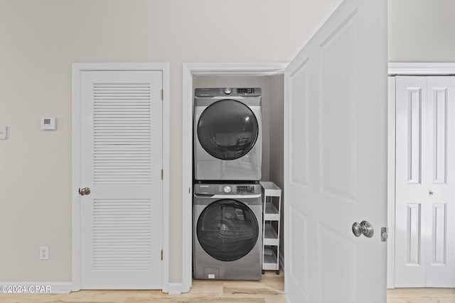 laundry room featuring light wood-type flooring and stacked washer and dryer