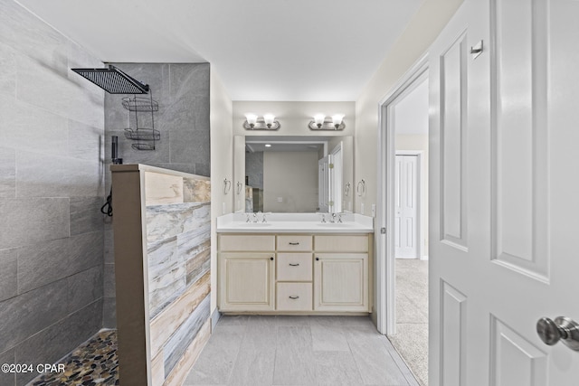 bathroom with tiled shower and vanity