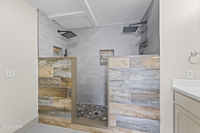 bathroom with a tile shower, tile patterned flooring, and vanity