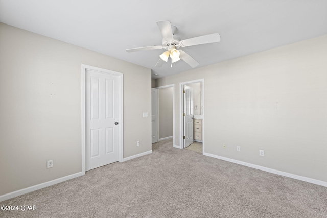 unfurnished bedroom with light colored carpet, ceiling fan, and ensuite bathroom