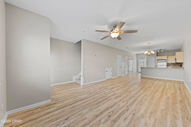 unfurnished living room with light wood-type flooring and ceiling fan with notable chandelier