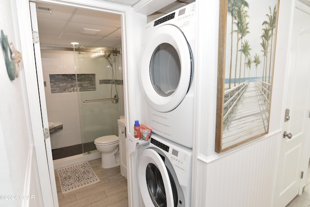 laundry area featuring light wood-style flooring, stacked washing maching and dryer, laundry area, and visible vents