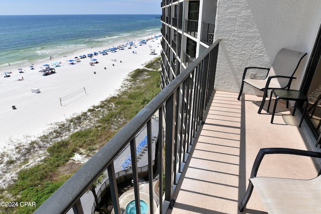 balcony featuring a water view and a beach view