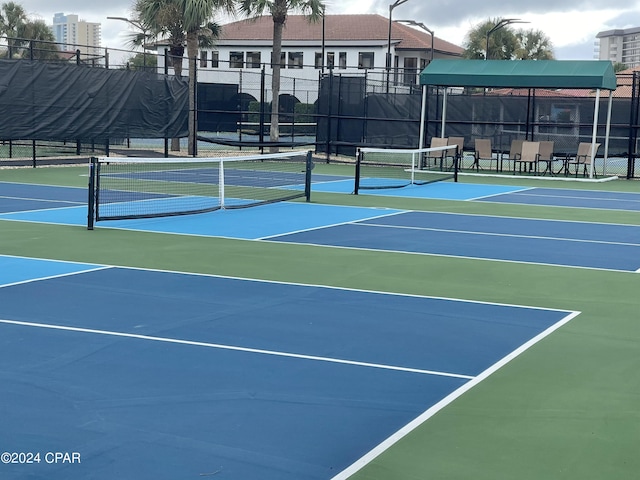 view of tennis court featuring fence and community basketball court