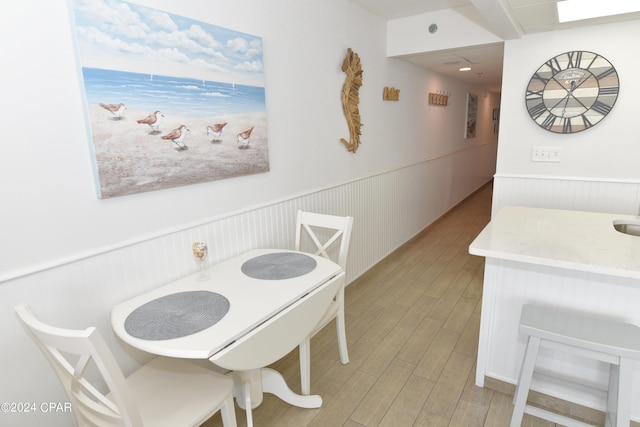 dining space featuring a wainscoted wall and light wood-style floors