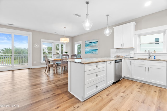 kitchen with white cabinets, light hardwood / wood-style floors, and decorative light fixtures