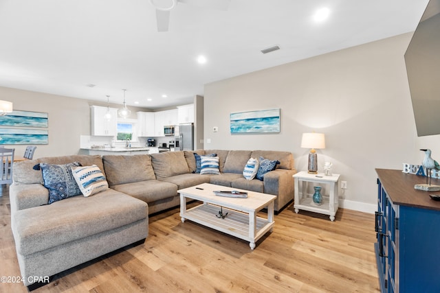 living room featuring light hardwood / wood-style floors and ceiling fan