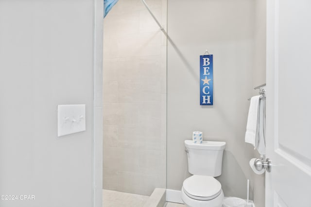 bathroom featuring toilet and tiled shower