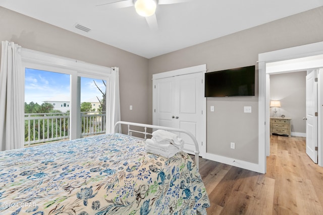 bedroom featuring access to outside, hardwood / wood-style floors, ceiling fan, and a closet