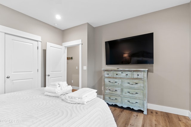 bedroom with light wood-type flooring and a closet