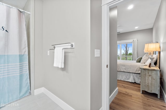 bathroom featuring curtained shower and hardwood / wood-style floors