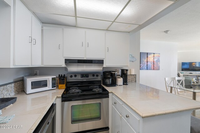 kitchen featuring appliances with stainless steel finishes, kitchen peninsula, and white cabinetry